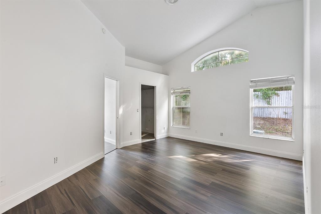 608 Bridge Creek Boulevard Ocoee, FL 34761 - Photo 9 of 17 an empty room with wooden floor chandelier and windows