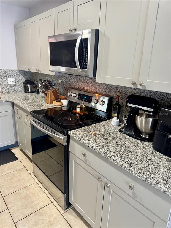 2379 Flamingo Way Winter Park, FL 32792 - Photo 15 of 25 a kitchen with stainless steel appliances granite countertop a stove and a microwave