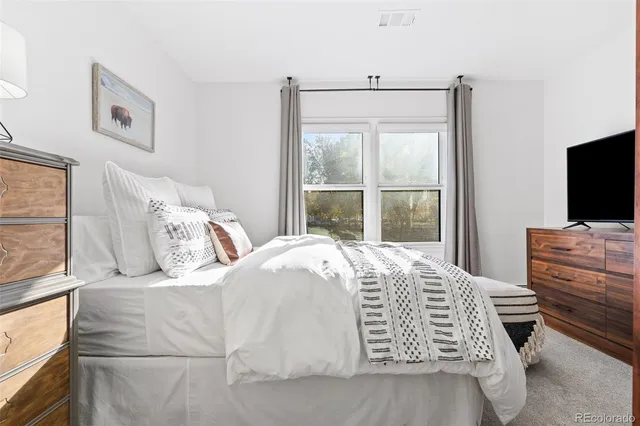 a bedroom with a bed and flat screen tv