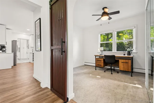 a view of a workspace with furniture and a window