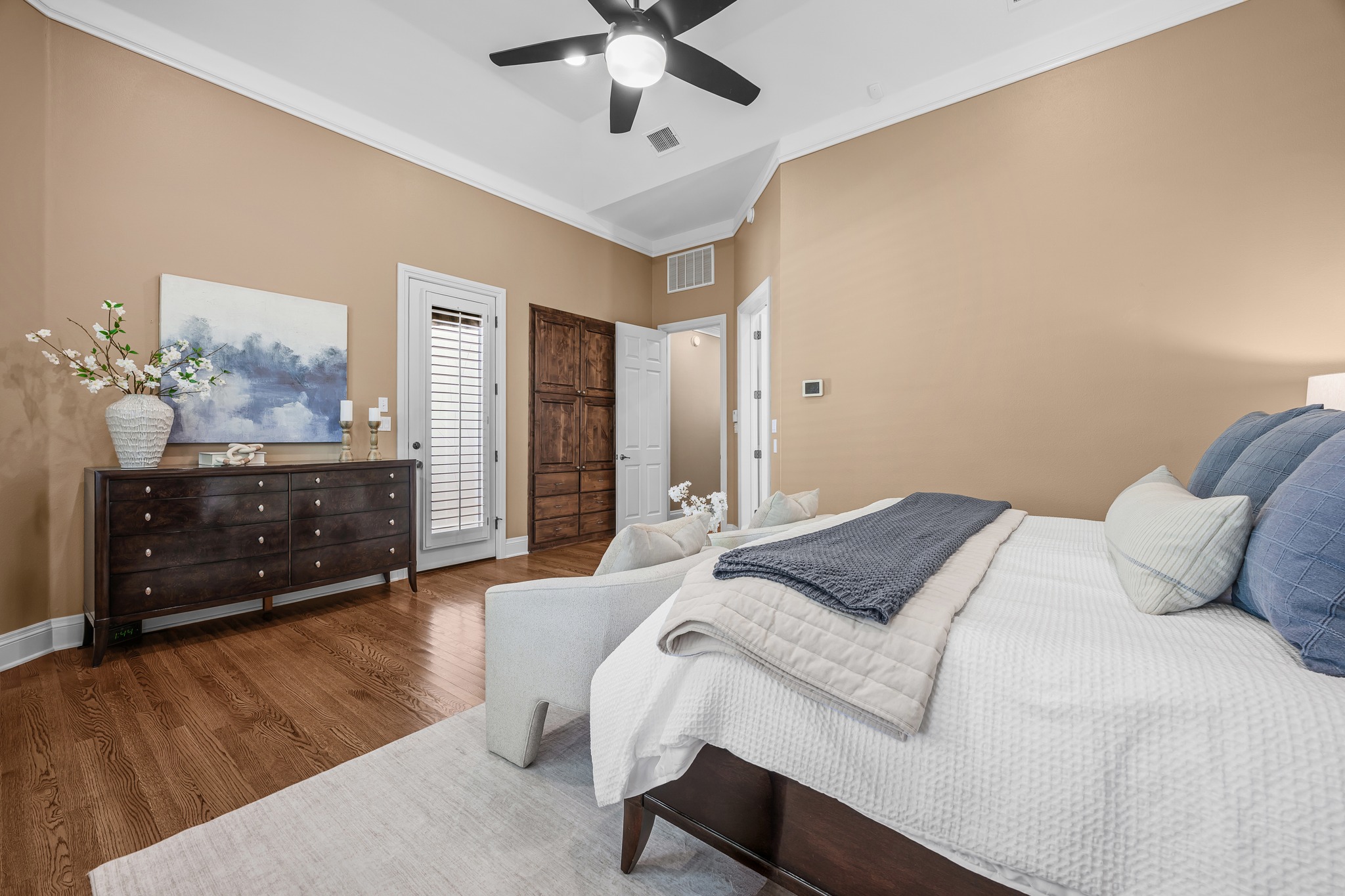 5200 Rico Cove Austin, TX 78731 - Photo 18 of 40 Hardwood floors and tray ceilings elevate this primary suite featuring built-in wooden cabinetry.