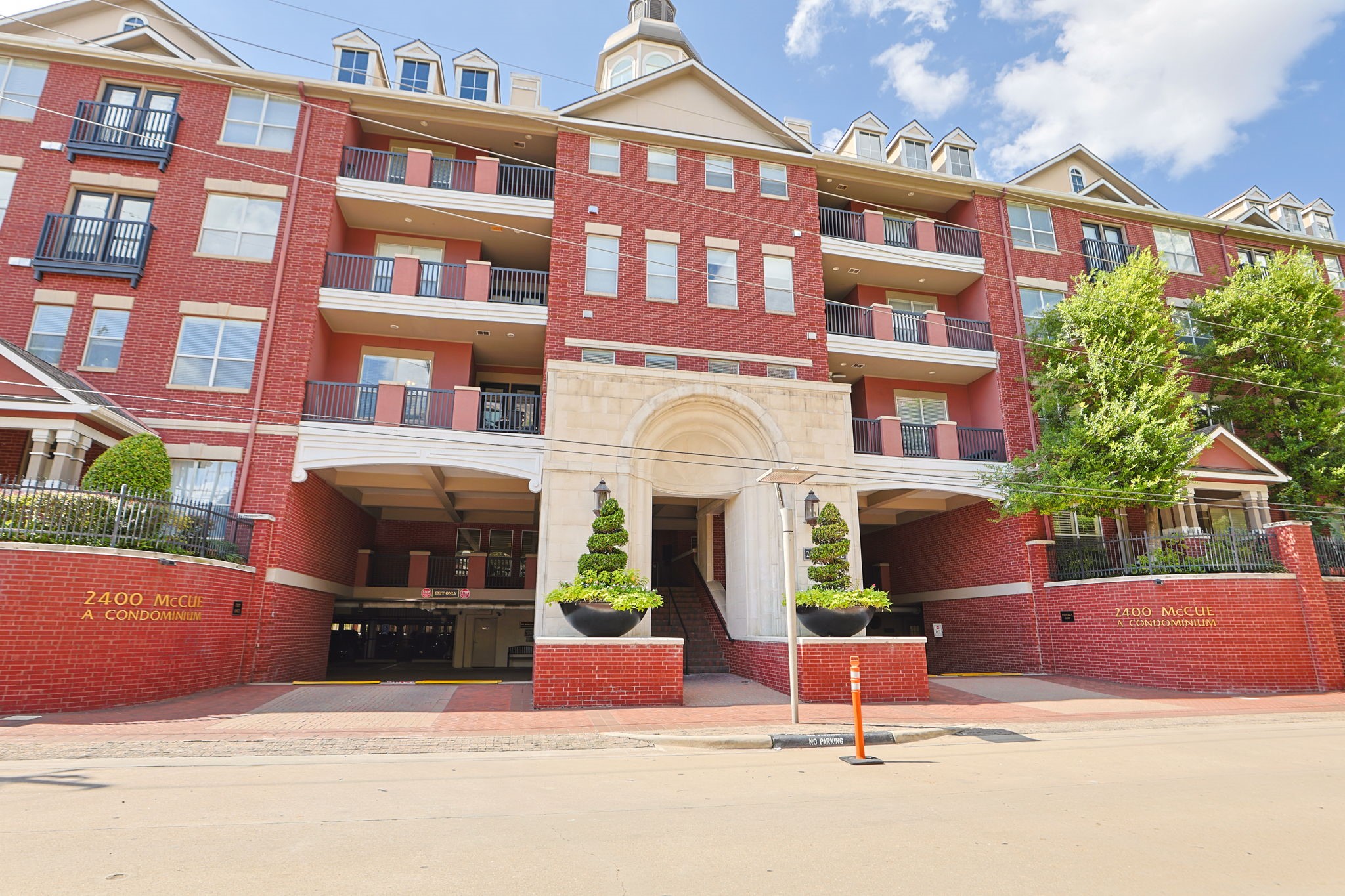 2400 South McCue Road, Unit 104 Houston, TX 77056 - Photo 3 of 38 Discover the perfect blend of elegance and convenience with this striking red brick condominium, featuring a welcoming entrance to the secure parking garage of McCues Management's Office.