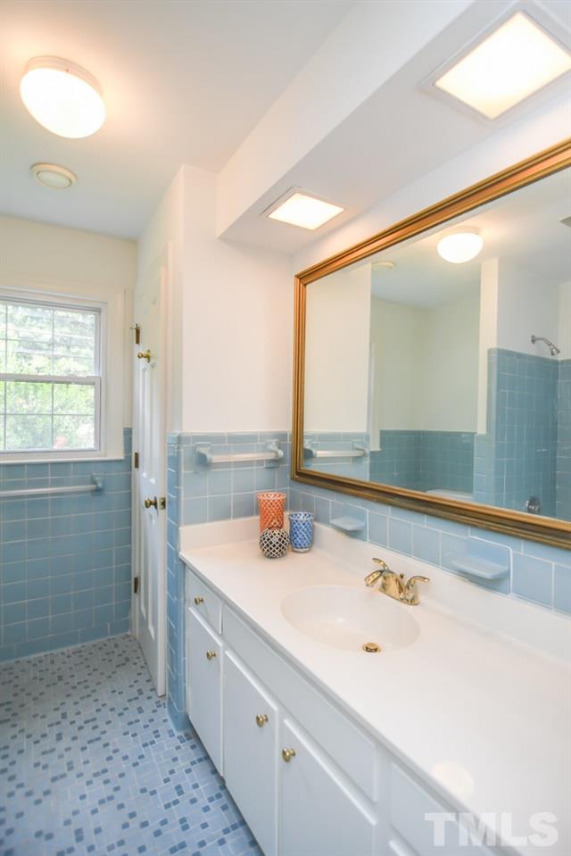 409 May Court Raleigh, NC 27609 - Photo 19 of 25 a bathroom with a tub a sink and a large mirror