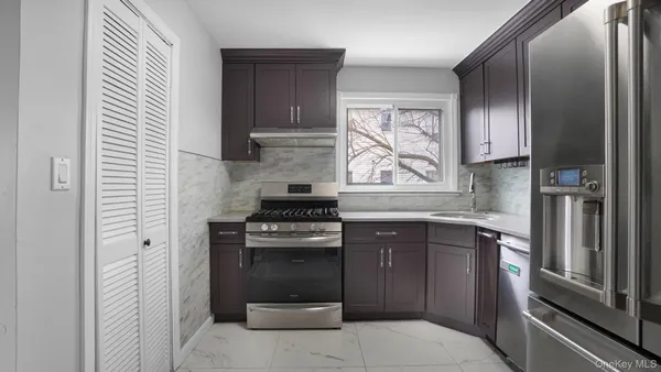 a kitchen with stainless steel appliances granite countertop a stove a refrigerator and a sink