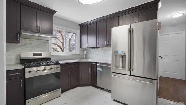 a kitchen with stainless steel appliances granite countertop a refrigerator and a stove top oven