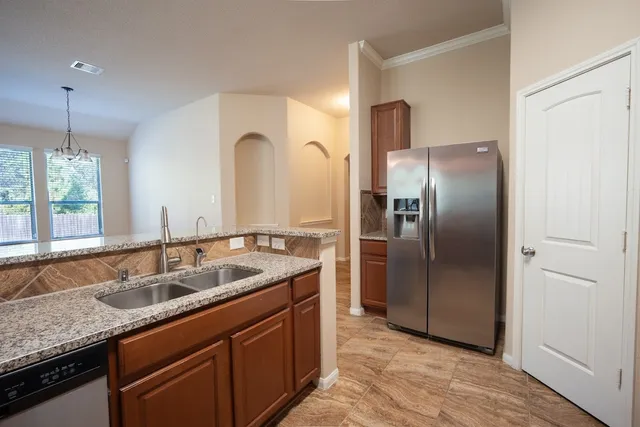 a kitchen with stainless steel appliances granite countertop a sink and a refrigerator