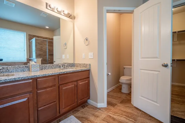 a bathroom with a granite countertop sink toilet and shower