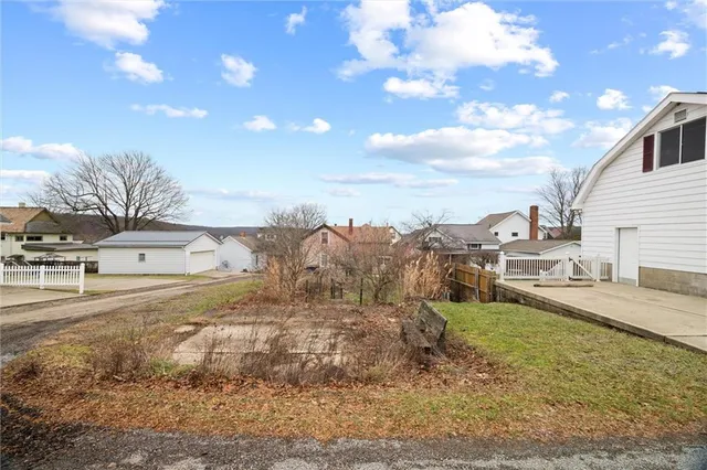 a view of a yard with wooden fence