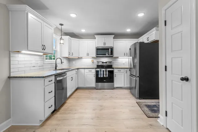 a kitchen with stainless steel appliances granite countertop a refrigerator and a stove top oven