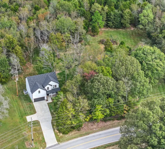 an aerial view of a house with a yard and lake view