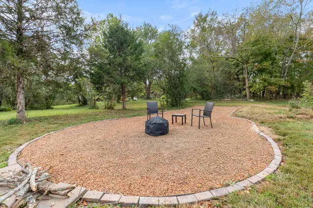 a view of a house with a big yard and large trees