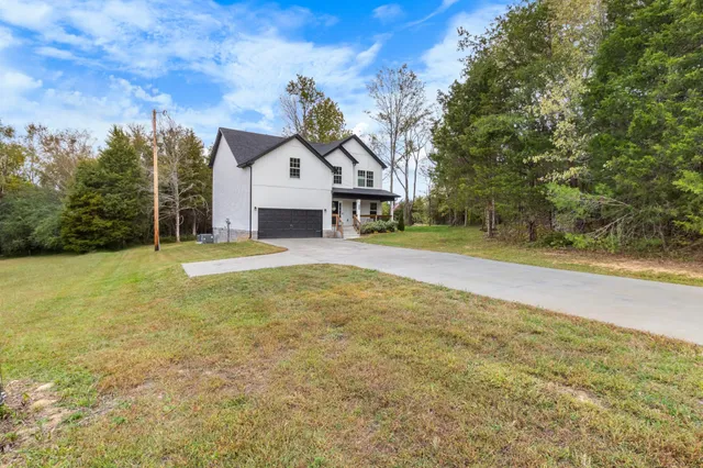 a view of a house with a yard and garage