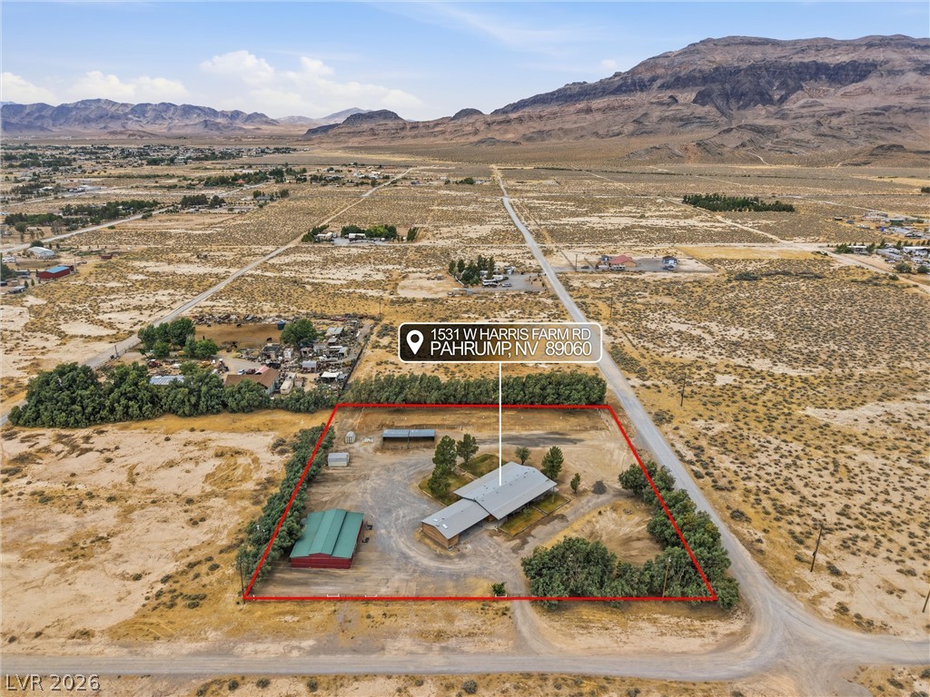 1531 West Harris Farm Road Pahrump, NV 89060 - Photo 2 of 37 An aerial perspective showcases a rural property with abundant acreage set against distant mountain ranges.