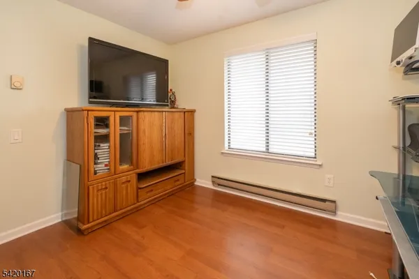 an empty room with windows cabinet and flat screen tv
