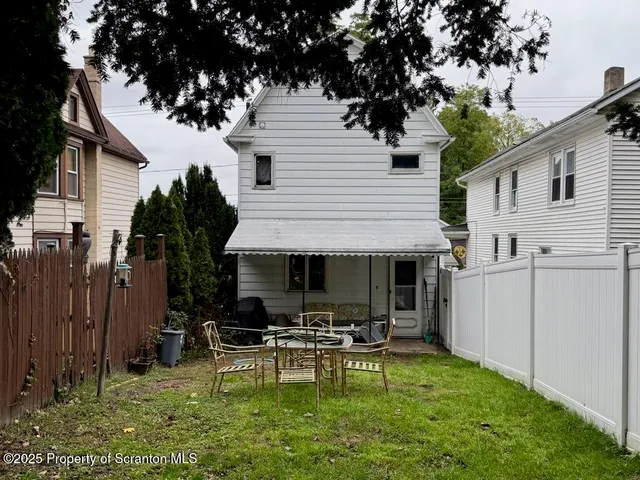 a view of backyard of house with outdoor seating and green space