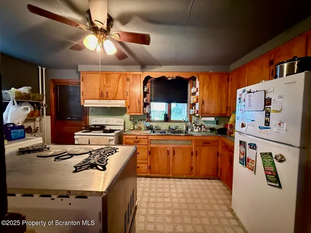a kitchen with kitchen island granite countertop a sink a counter top space appliances and cabinets
