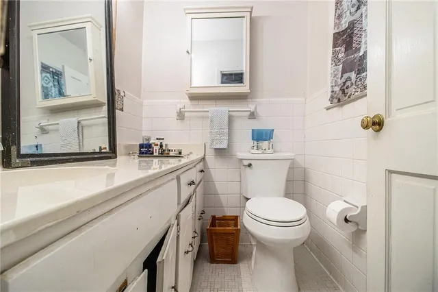 a bathroom with a granite countertop toilet sink and mirror