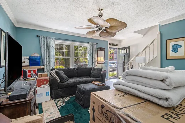 a living room with furniture ceiling fan and a window