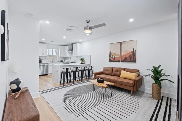 a living room with furniture and a view of kitchen
