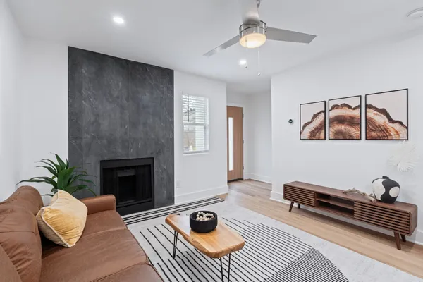 a living room with furniture a fireplace and a wooden floor