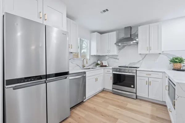 a kitchen with a stove and white cabinets