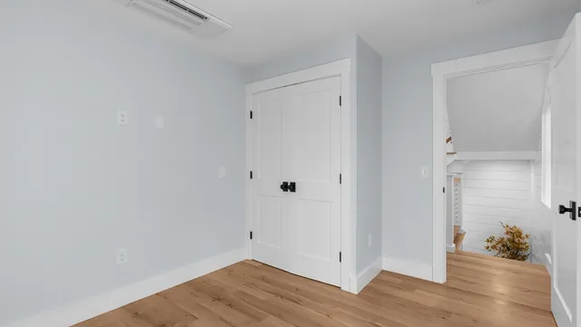 a view of a bathroom with wooden floor and a window