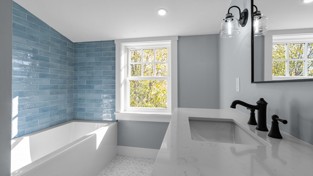 39 Connection Street Newport, RI 02840 - Photo 9 of 40 a bathroom with a tub a sink a window and a shower