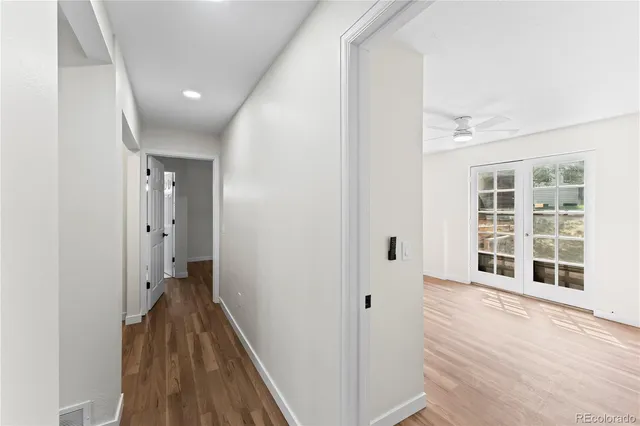 a view of a hallway with wooden floor and windows