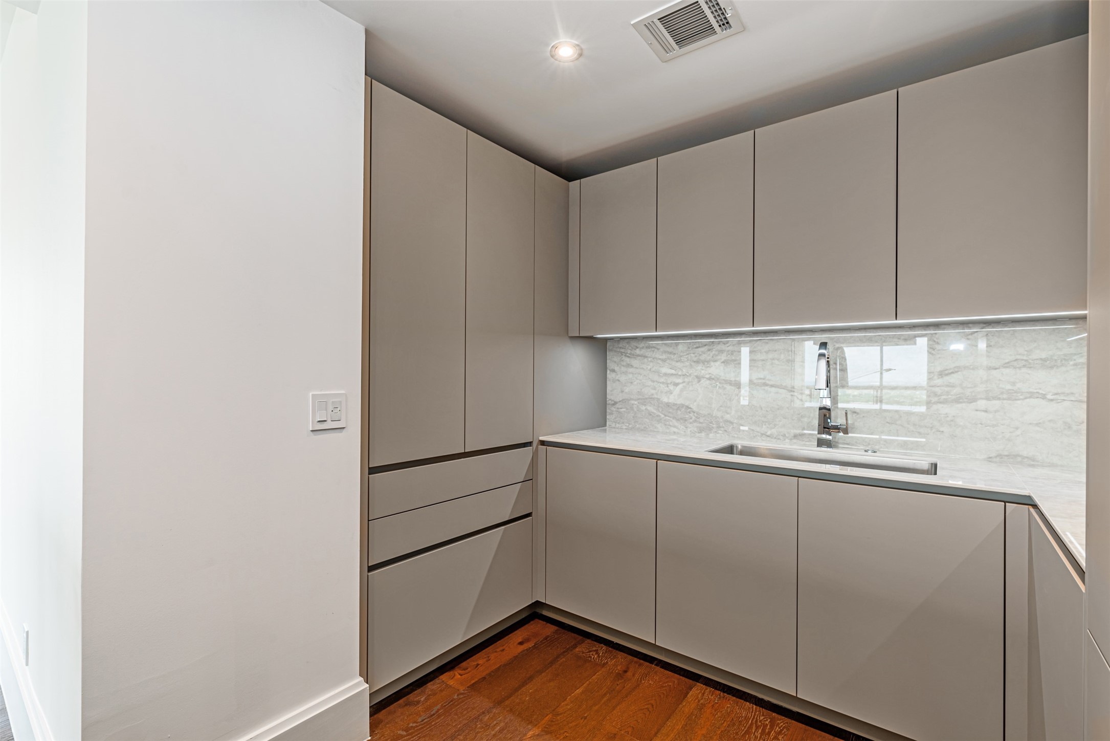 1701 Hermann Drive, Unit 34L Houston, TX 77004 - Photo 7 of 37 Porcelain countertops and sleek handless push latch cabinets for ultimate convenience.
