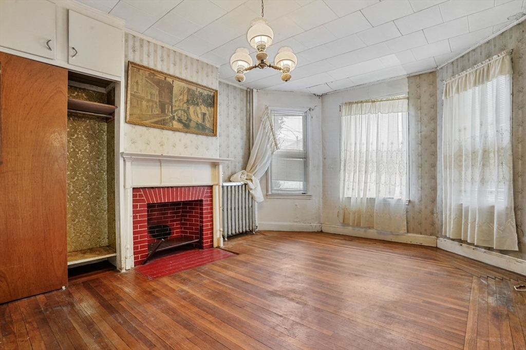 1 Copley Street Boston, MA 02119 - Photo 11 of 29 a view of an empty room with wooden floor fireplace and a window