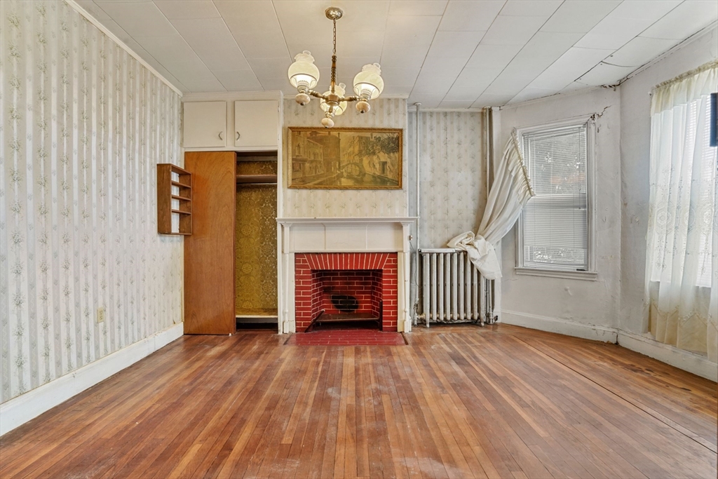 1 Copley Street Boston, MA 02119 - Photo 12 of 29 an empty room with wooden floor fireplace and windows