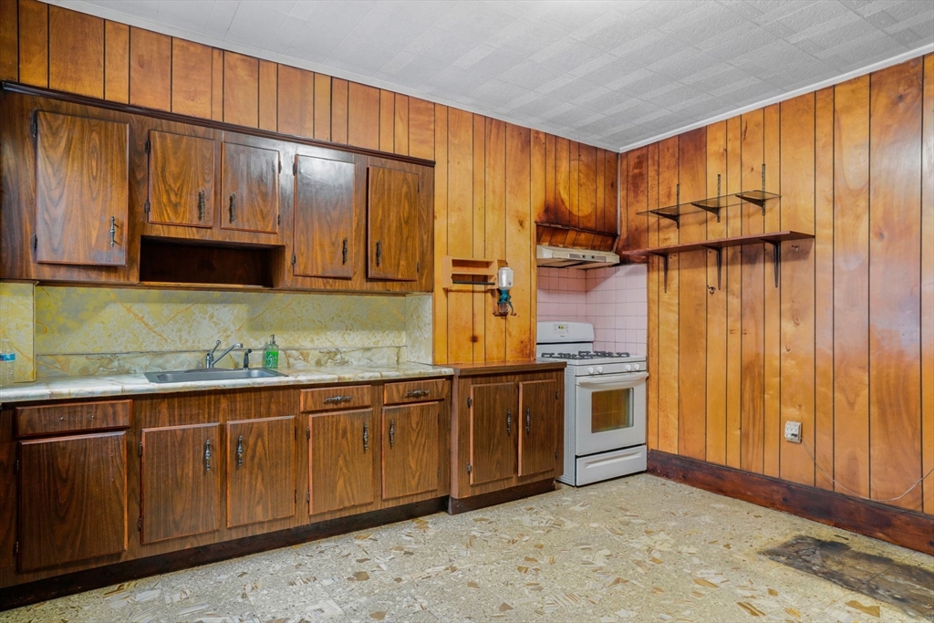 1 Copley Street Boston, MA 02119 - Photo 17 of 29 a kitchen with stainless steel appliances granite countertop wooden cabinets a sink and a refrigerator