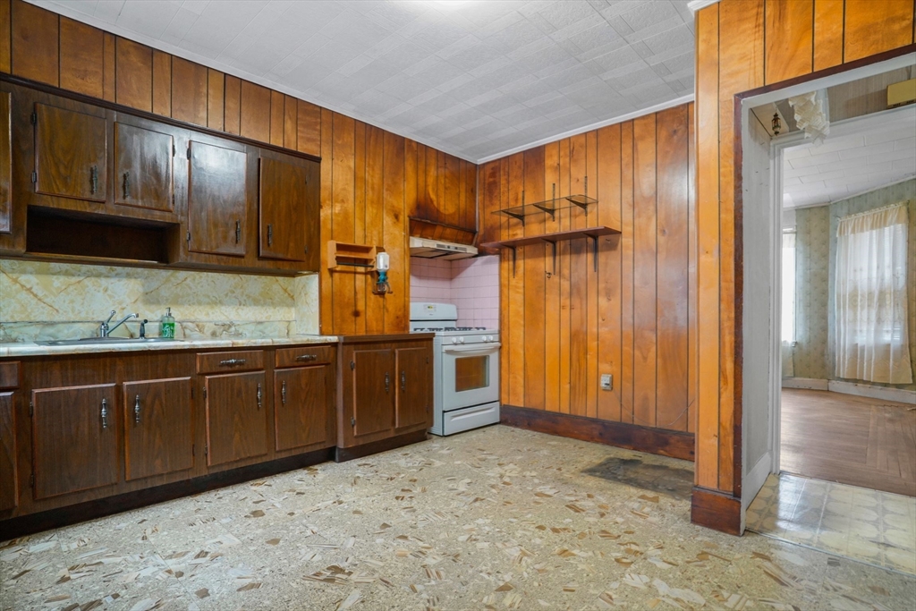 1 Copley Street Boston, MA 02119 - Photo 19 of 29 a kitchen with stainless steel appliances granite countertop wooden cabinets a sink and dishwasher