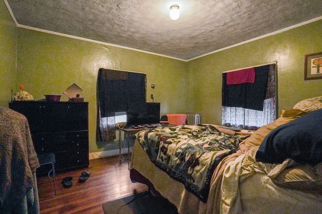 1 Copley Street Boston, MA 02119 - Photo 24 of 29 a bedroom with a bed and a flat tv screen on the dresser