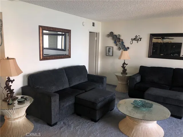 a living room with furniture and a mirror