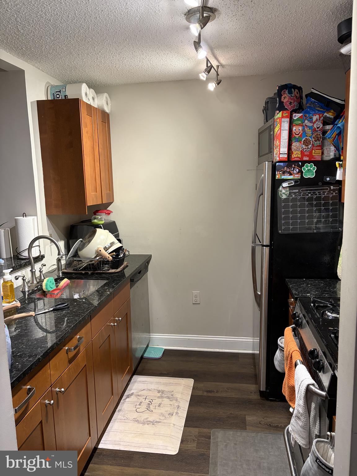 20979 Timber Ridge Terrace, Unit 204 Ashburn, VA 20147 - Photo 6 of 6 a kitchen with stainless steel appliances granite countertop a stove a sink and a microwave