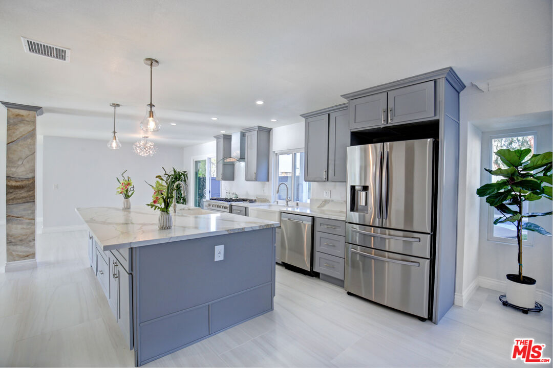 33051 Daniel Drive Dana Point, CA 92629 - Photo 9 of 30 a kitchen with kitchen island white cabinets and stainless steel appliances