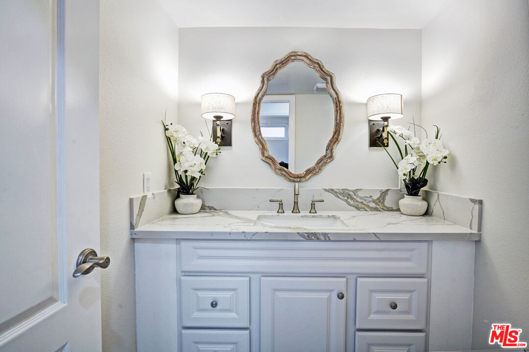 33051 Daniel Drive Dana Point, CA 92629 - Photo 10 of 30 a bathroom with a granite countertop sink a mirror and a potted plant