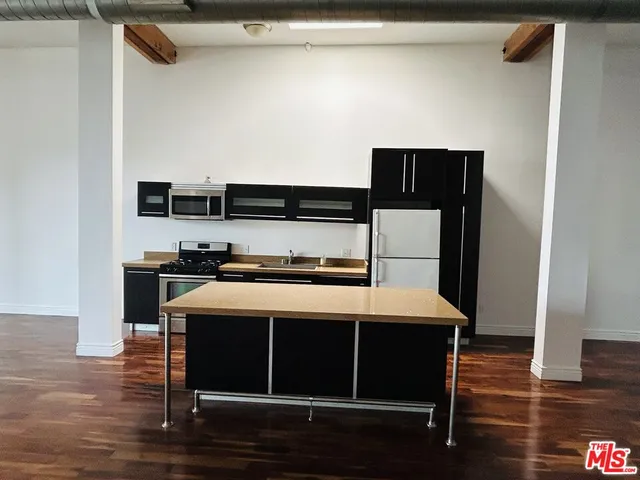 a bedroom with a bed and a view of kitchen