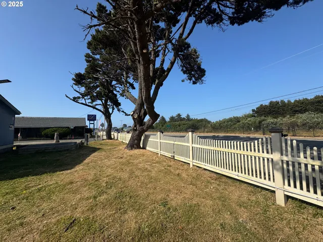 a view of a yard with wooden fence