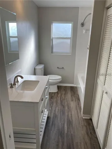 a view of a room with wooden floor and windows