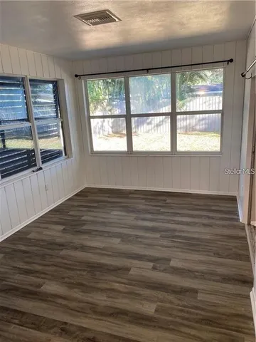 a view of a hallway with wooden floor and windows