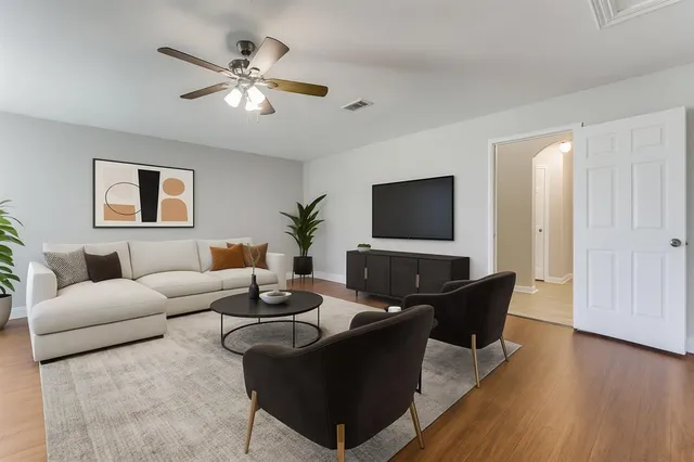 a living room with furniture and a flat screen tv with wooden floor