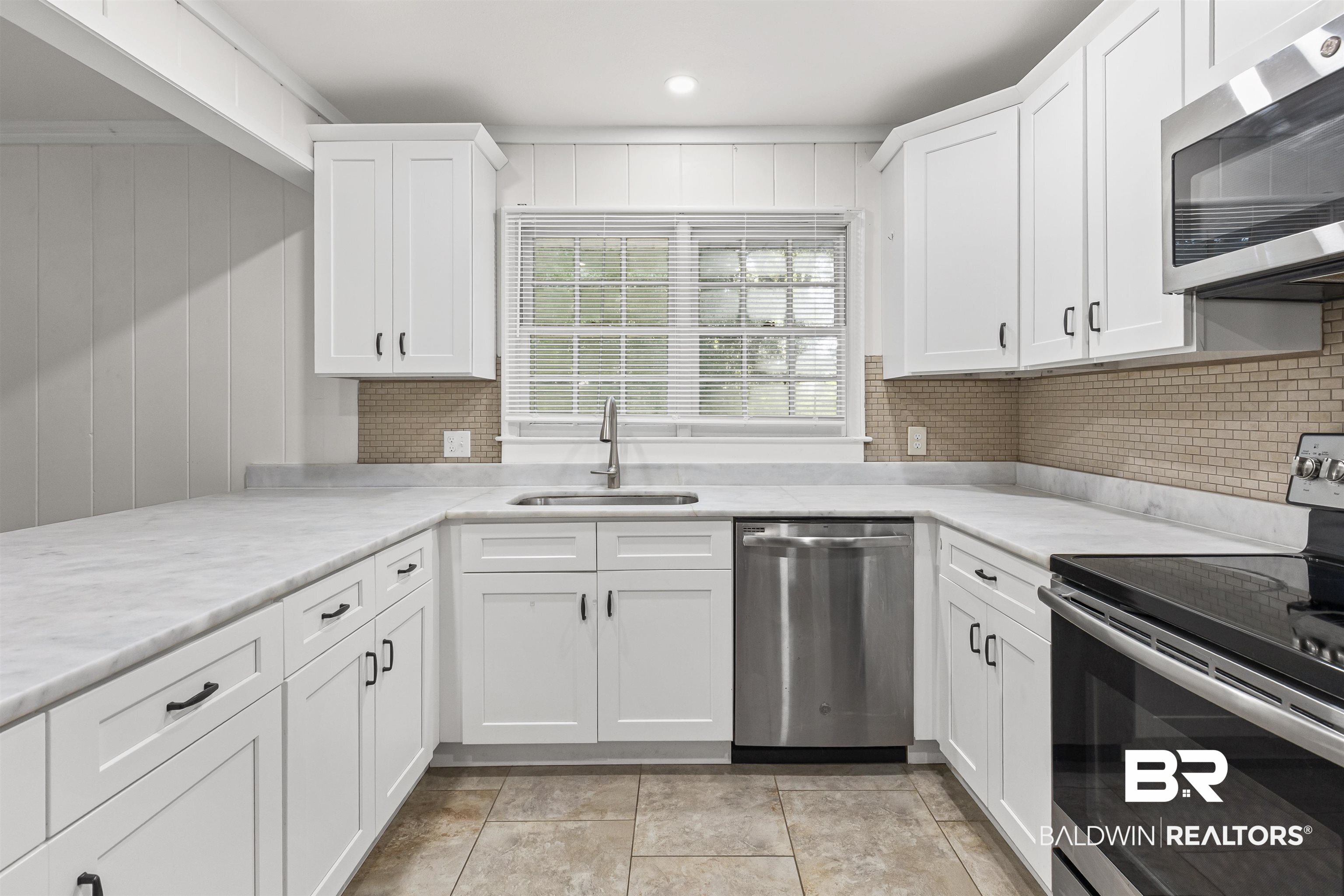 1108 Locarno Street Mobile, AL 36608 - Photo 8 of 24 Kitchen with appliances with stainless steel finishes, white cabinetry, light stone counters, decorative backsplash, and recessed lighting