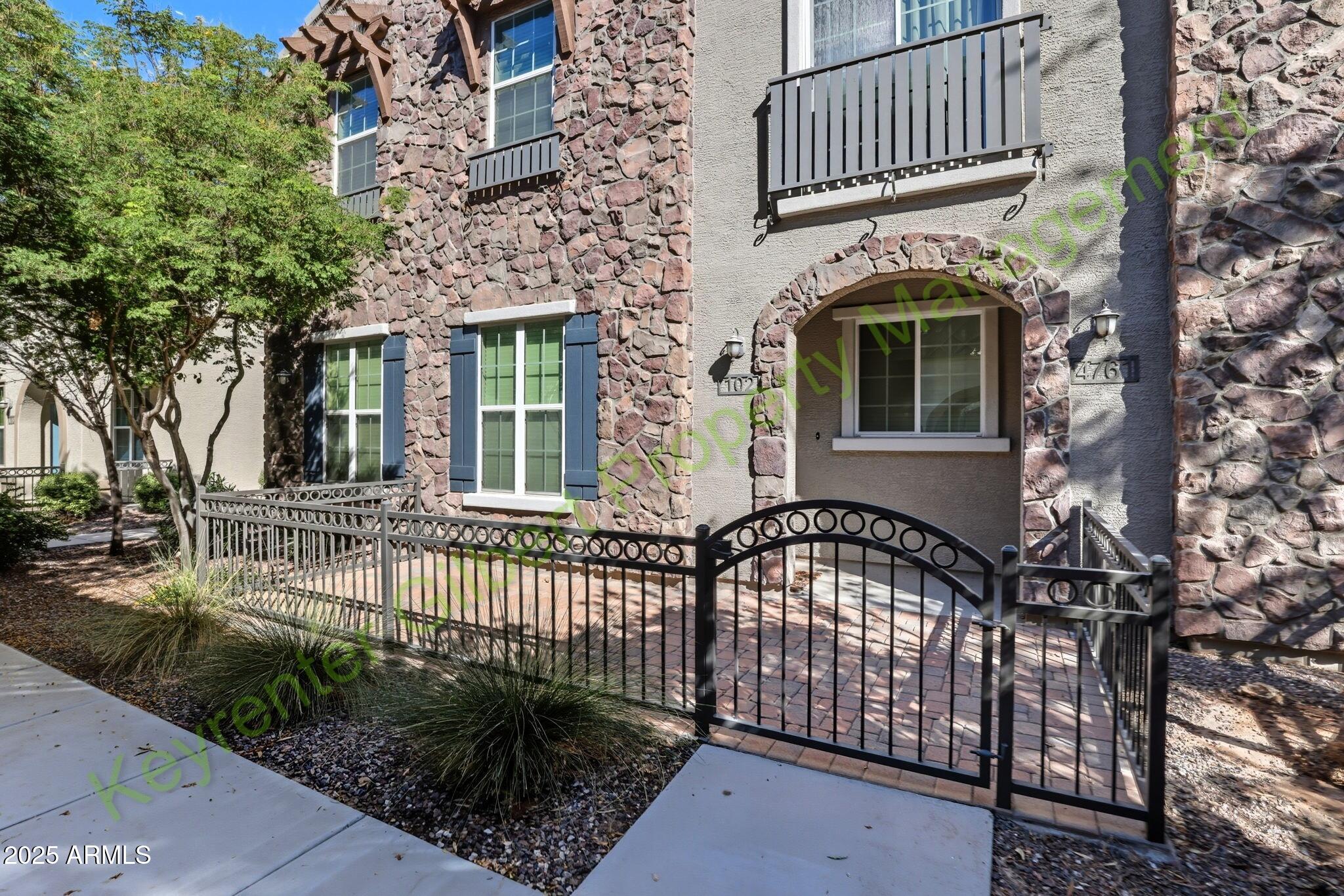 4761 East Portola Valley Drive, Unit 102 Gilbert, AZ 85297 - Photo 1 of 34 a front view of a house with a garden