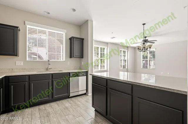 a large kitchen with kitchen island a sink a counter top space and cabinets
