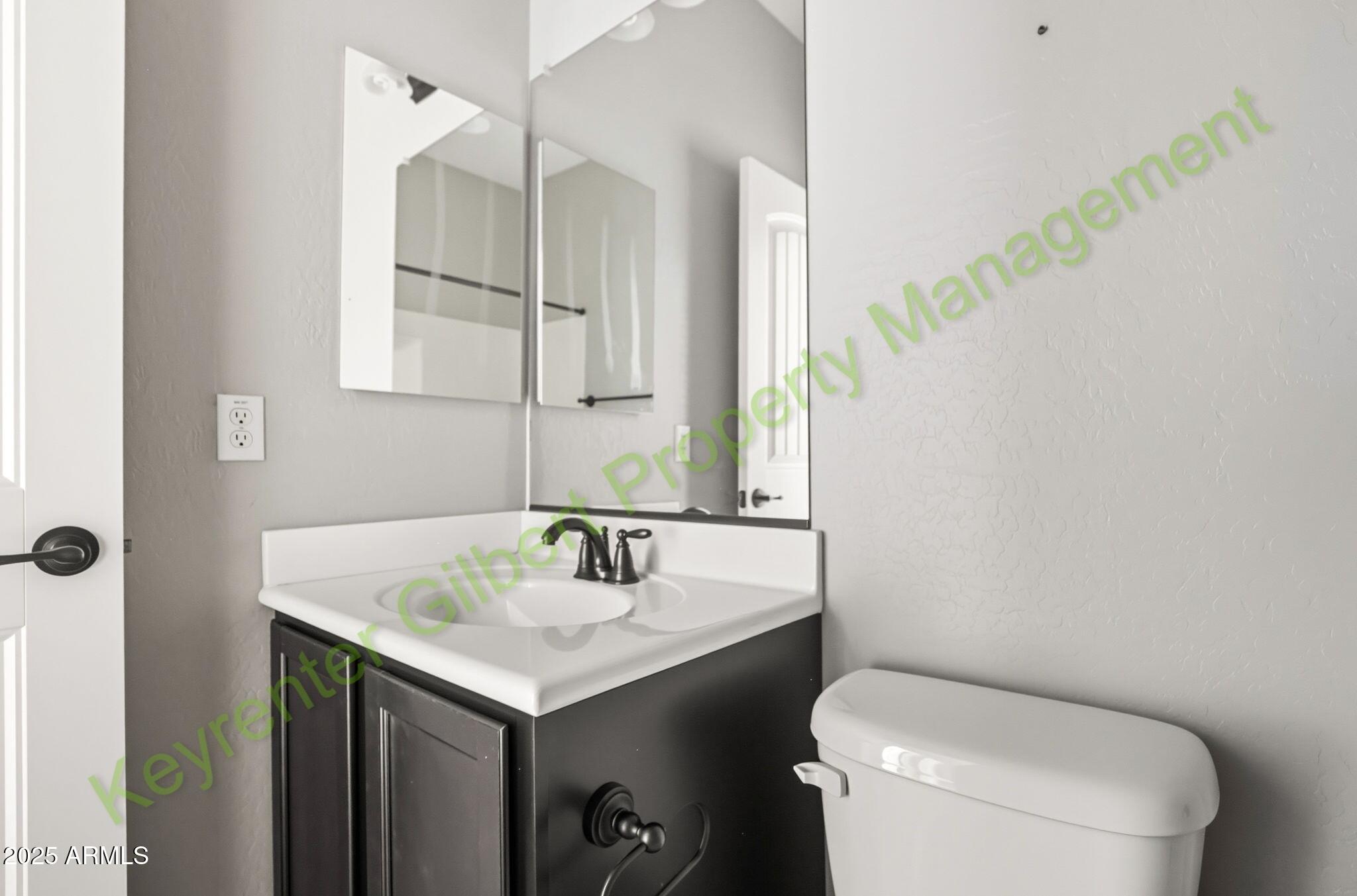 4761 East Portola Valley Drive, Unit 102 Gilbert, AZ 85297 - Photo 15 of 34 a bathroom with a sink toilet and mirror