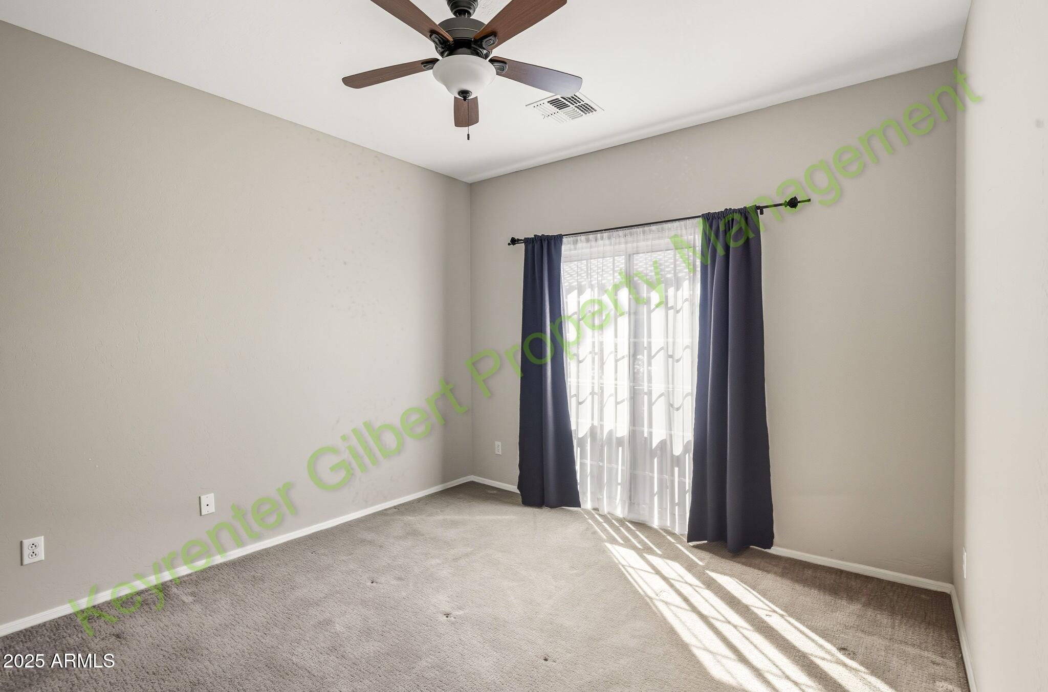 4761 East Portola Valley Drive, Unit 102 Gilbert, AZ 85297 - Photo 21 of 34 an empty room with a window and a fan
