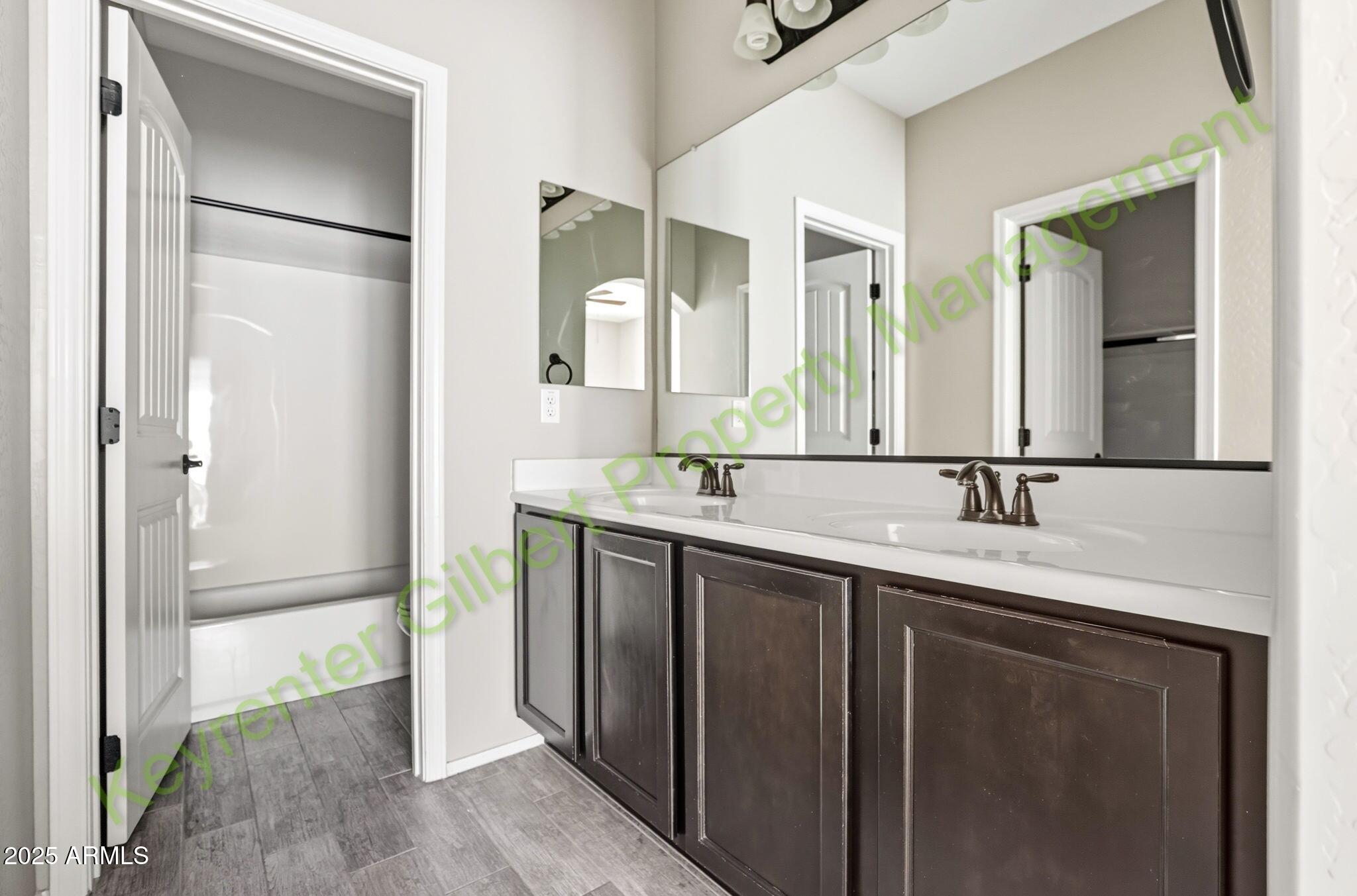 4761 East Portola Valley Drive, Unit 102 Gilbert, AZ 85297 - Photo 23 of 34 a bathroom with a double vanity sink and mirror