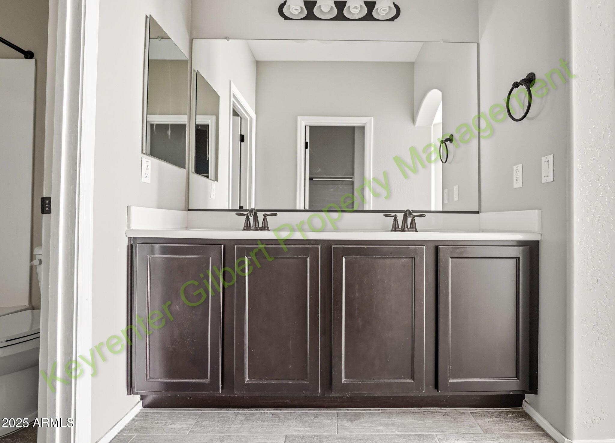 4761 East Portola Valley Drive, Unit 102 Gilbert, AZ 85297 - Photo 24 of 34 a bathroom with a granite countertop sink and a mirror
